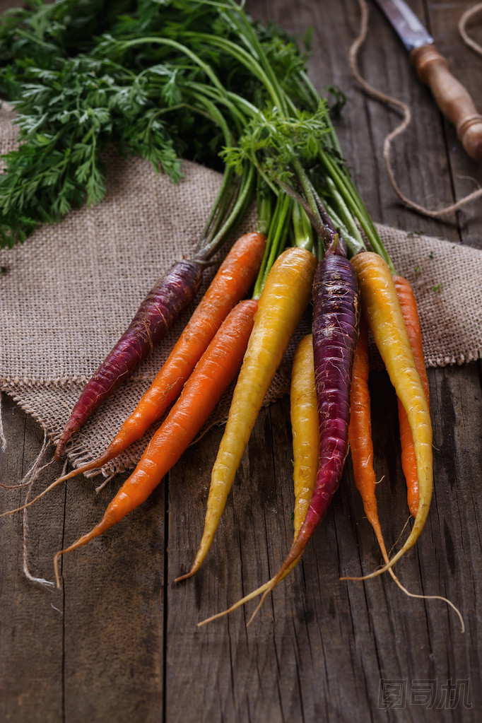 在仿古木制背景彩色的胡蘿卜圖片