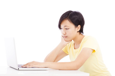 疲憊的女子，在一臺筆記本電腦，在白色背景上孤立