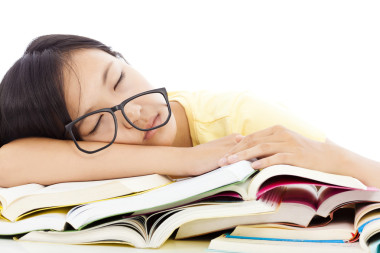 疲倦的學(xué)生戴眼鏡睡在書(shū)上的那個(gè)姑娘