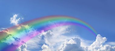 在廣闊的藍色天空的彩虹圖片