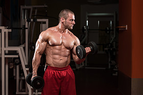 年轻的健美运动员做二头肌重量锻