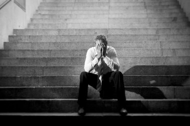 哭的商人失去了坐在街頭的水泥樓梯上的凹陷