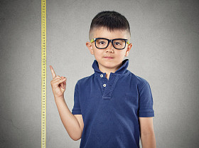 孩子指着他的身高上卷尺图片