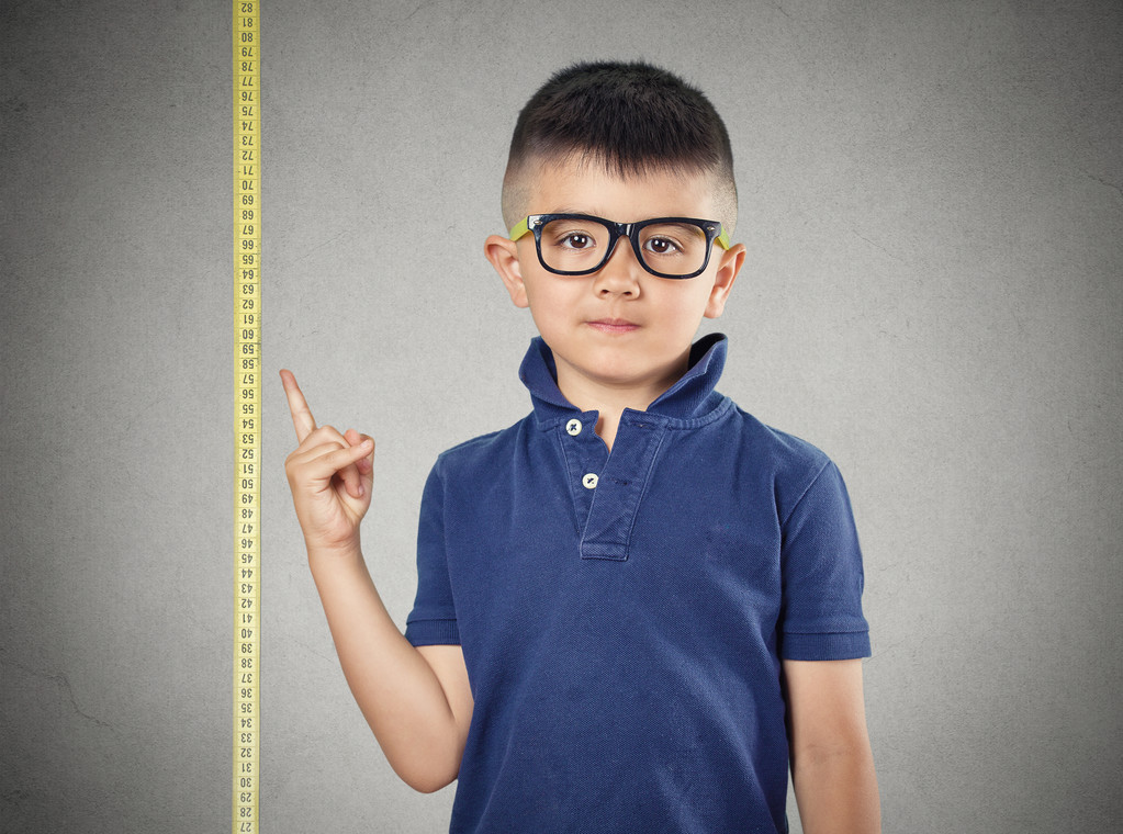 孩子指着他的身高上卷尺图片