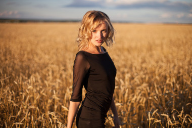 快乐的女人在金黄小麦照片