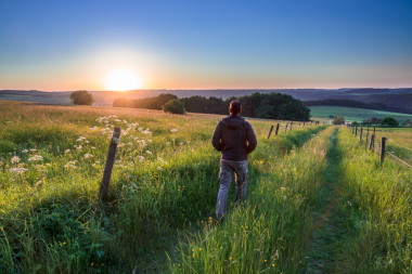 人走在轨道朝着日落照片