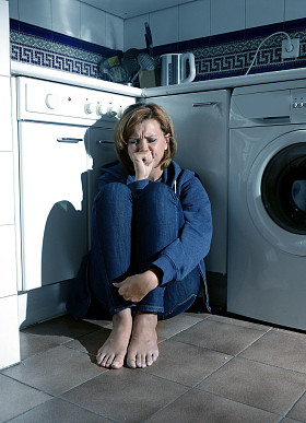 孤独和生病的女人，在应激抑郁和悲伤的厨房地板上哭泣