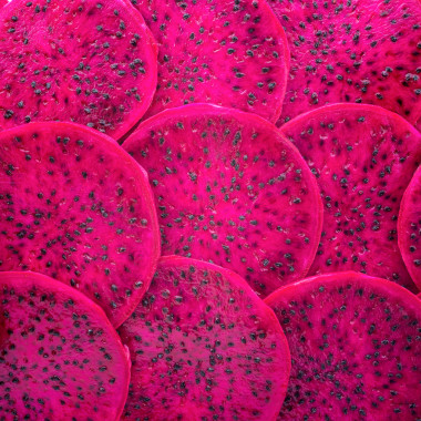 美麗的新鮮的切片的紅色的龍水果作為背景，火龍果