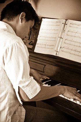 弹钢琴的亚洲人照片