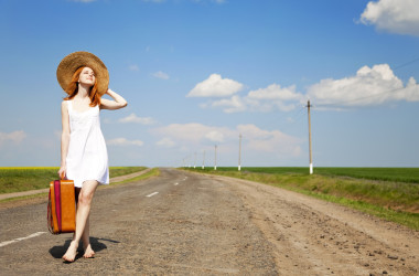 孤單的小女孩帶著手提箱在鄉(xiāng)村道路