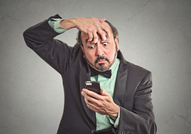 昏昏欲睡的男人試著保持清醒持有智能手機(jī)