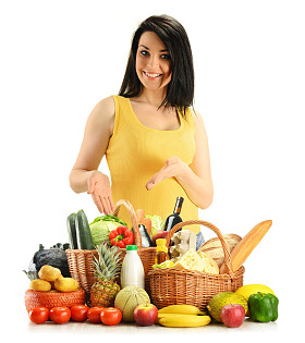 在柳条篮子上白色孤立杂货的年轻女子