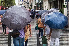 城市马路下雨天雨遮阳伞的人图片