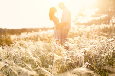 愛情侶接吻在日落時分，專注于前景