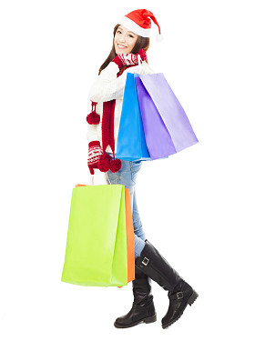 美丽快乐的年轻女子手持购物袋