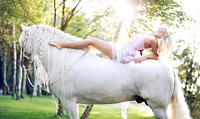 可爱的女人躺在雄伟的马