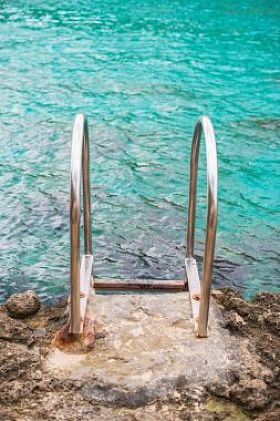 扶手安装在靠近大海的岩石.图片