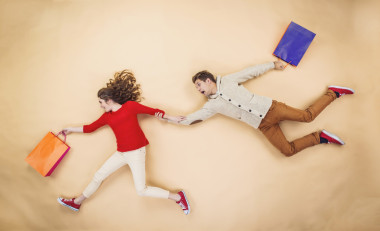 夫妇在圣诞帽运行与购物袋