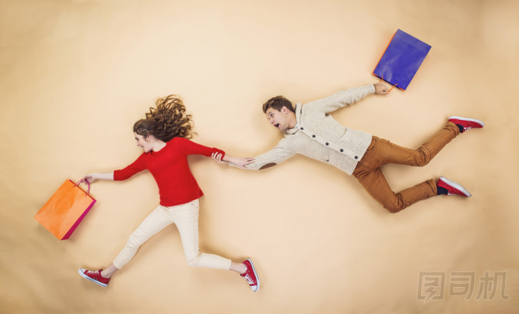 夫妇在圣诞帽运行与购物袋