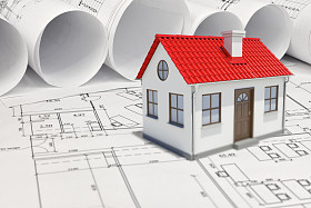 附近的建筑图纸卷轴的红顶小模型房子