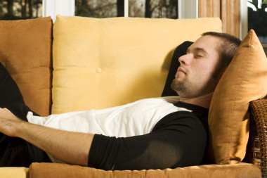 在客廳里的沙發(fā)上打瞌睡的年輕人