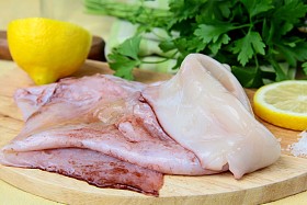 在一个厨房板上与草药和柠檬新鲜原料鱿