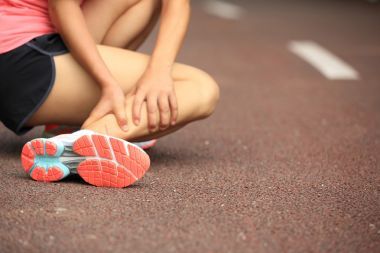 女跑步運動員舉行她扭到腳踝受傷