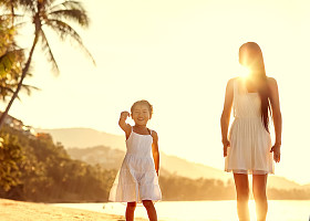 母亲和女儿幸福的爱在日落