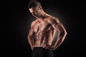 在深色背景上的工作室中的肌肉男