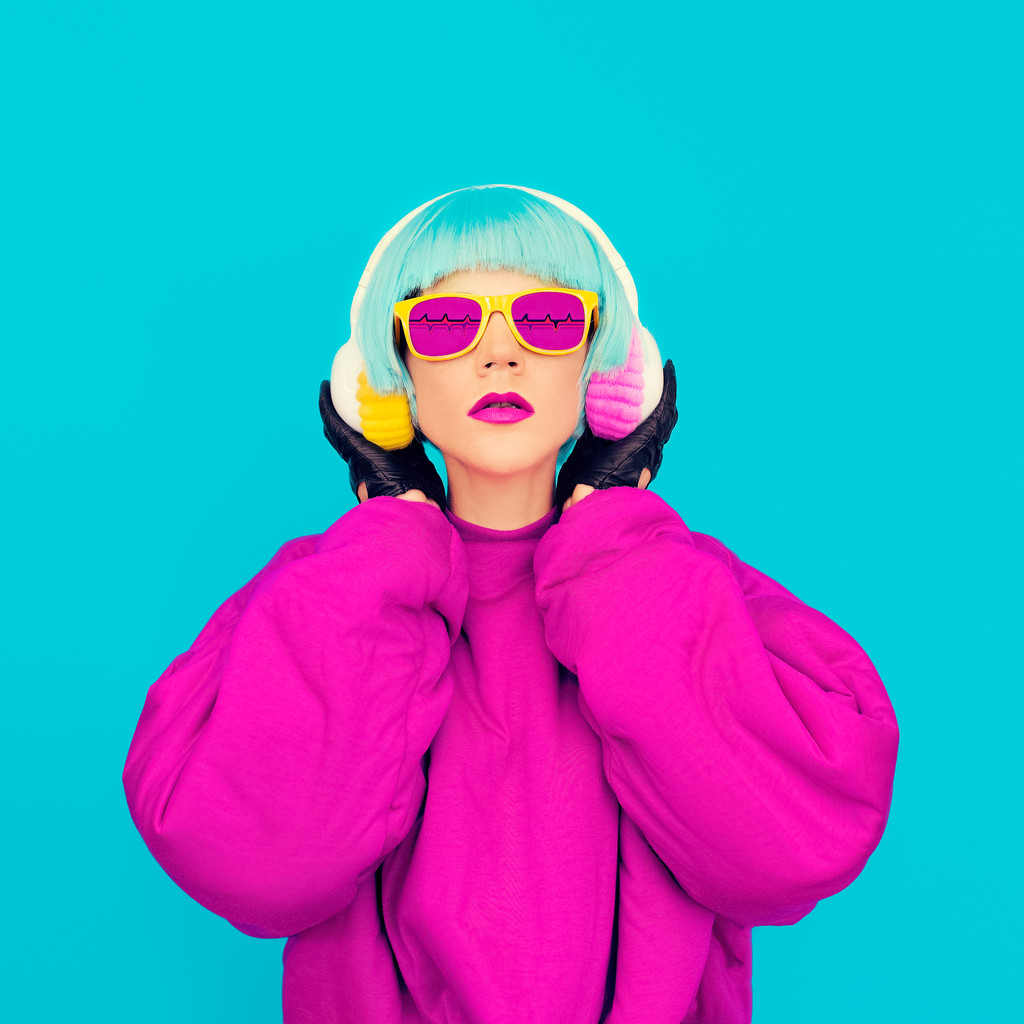 迷人的时尚女士在鲜艳的衣服，听听音乐。所有