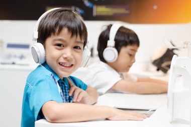 耳機在教室里的小男孩