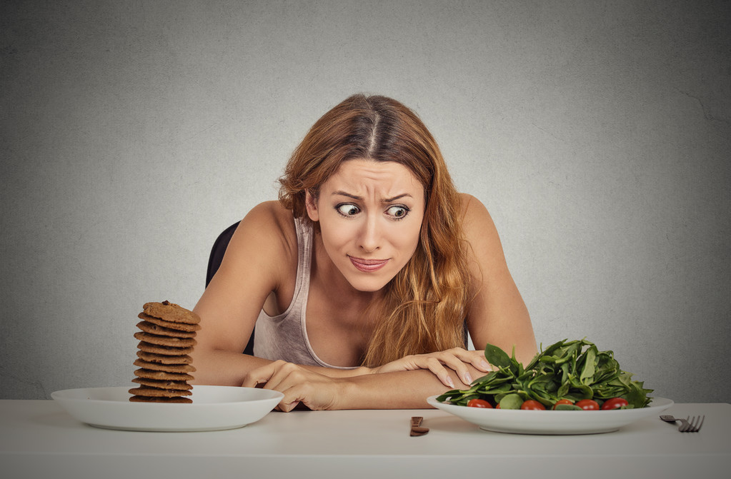 决定是否要吃健康的食物或甜饼干的女人她渴望