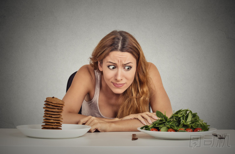 決定是否要吃健康的食物或甜餅干的女人她渴望