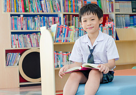 学校图书馆里的学生阅读本书照片