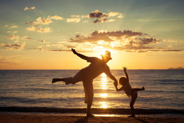 父亲和儿子在海滩上玩照片