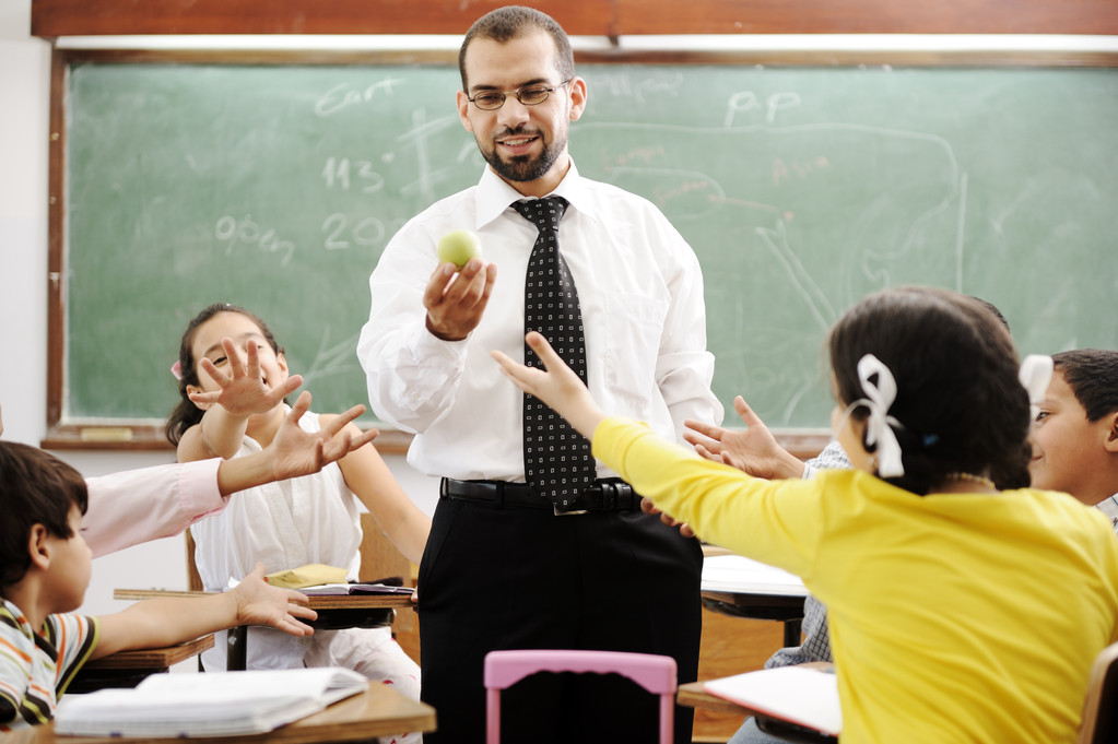 年轻的男老师与现代学校,活动中的儿童 年轻的男老师与现代学校,活动中的儿童
