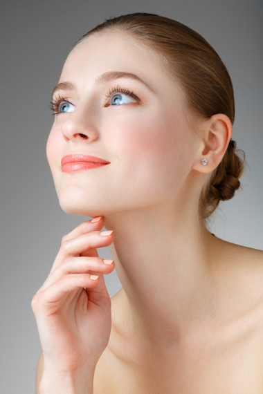 美丽的女人，摸她的脖子。微笑的蓝眼睛的女孩