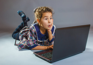 在筆記本灰色背景的地板上玩的青少年女孩