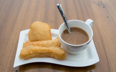 泰國炸的 doughstick 和木桌上的咖啡，早餐