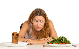 决定是否要吃健康的食物或甜饼干的女人