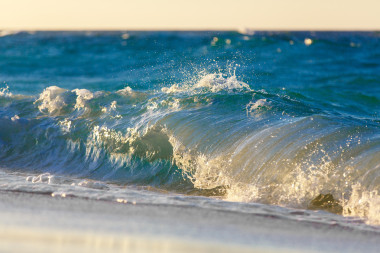 在熱帶海洋上日落海灘上的海浪