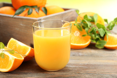 與箱橘子和木桌和明亮的背景上片杯橙