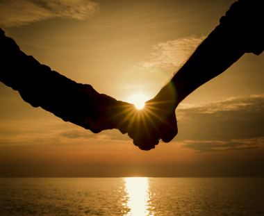 剪影夫婦的手在日落大道