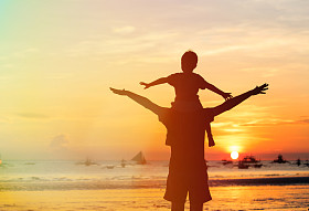 父亲和儿子玩着日落照片