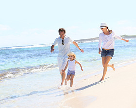 夫妇与运行在海滩上的女孩