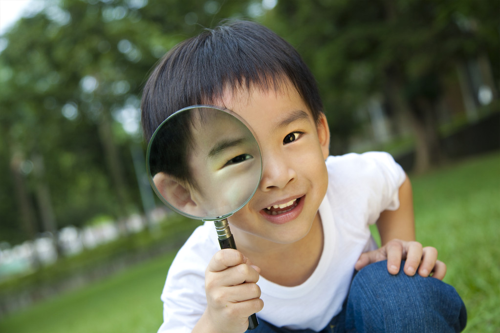 快乐的孩子用放大镜图片