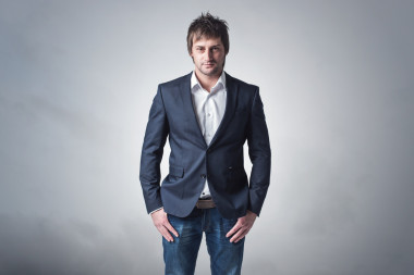 年輕的堅強(qiáng)和自信的男人正站，戲劇性的背景 skyclouds