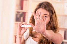 紧张的年轻女孩，抱着怀孕测试