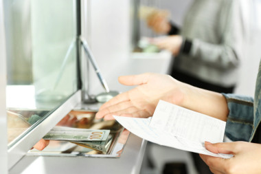 用钱现金部窗口中的女性手。货币交换概念