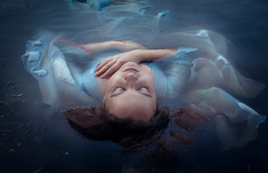 年輕美女穿著藍色的衣服，躺在水中淹死
